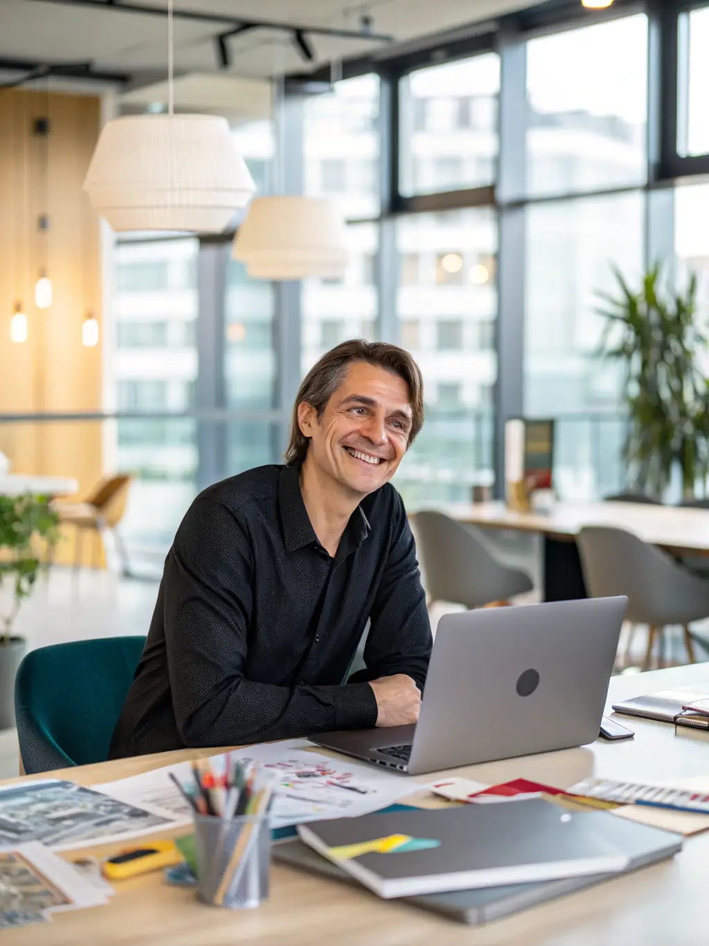 A person smiling confidently while working on a laptop in a bright and airy office, showcasing improved focus and mental clarity.
